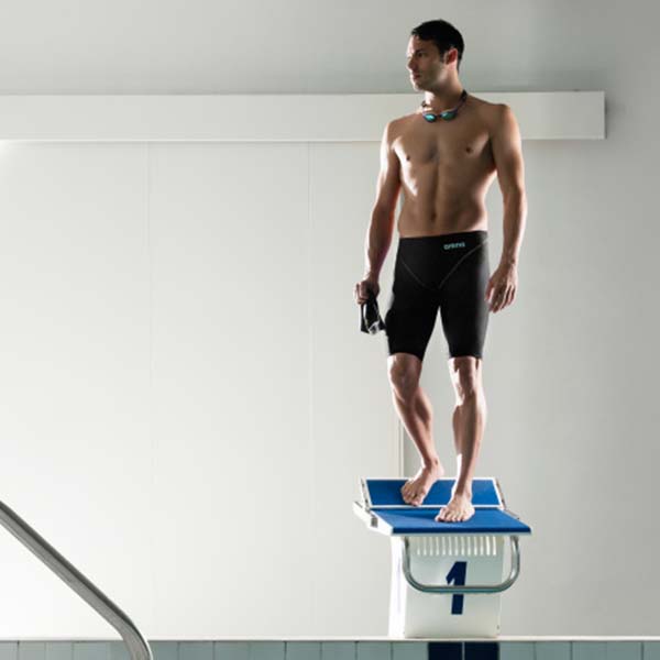 Man standing on Swim Starter Blocks wearing arena powerskin impulso jammers